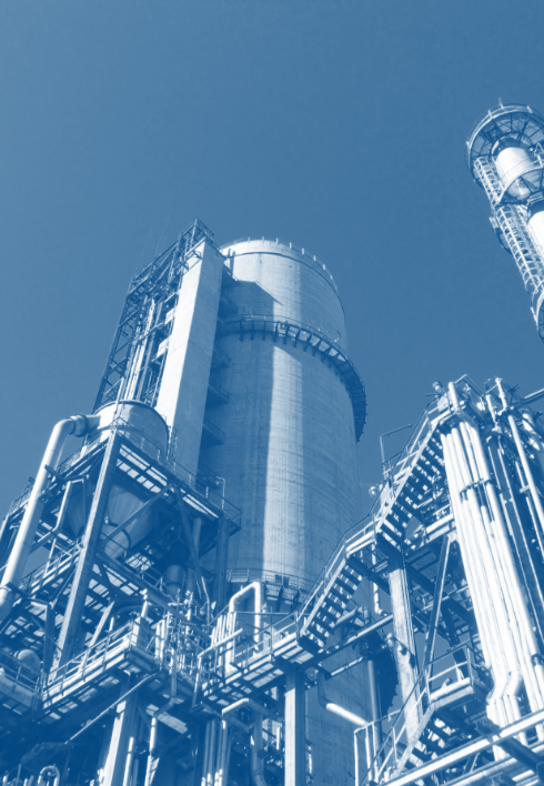 A blue and white photo of a factory with a blue sky in the background