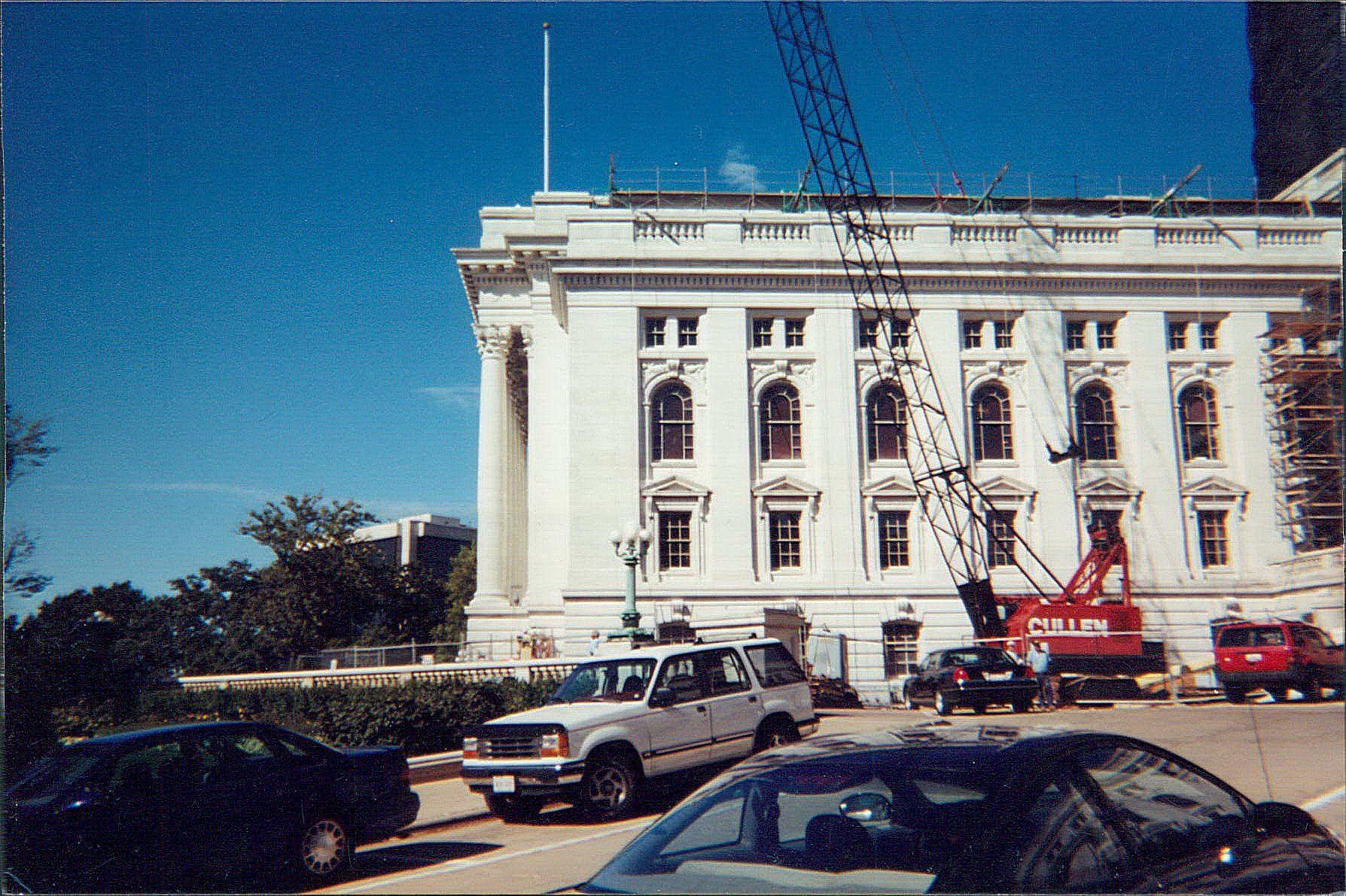 A large white building with cars parked in front of it