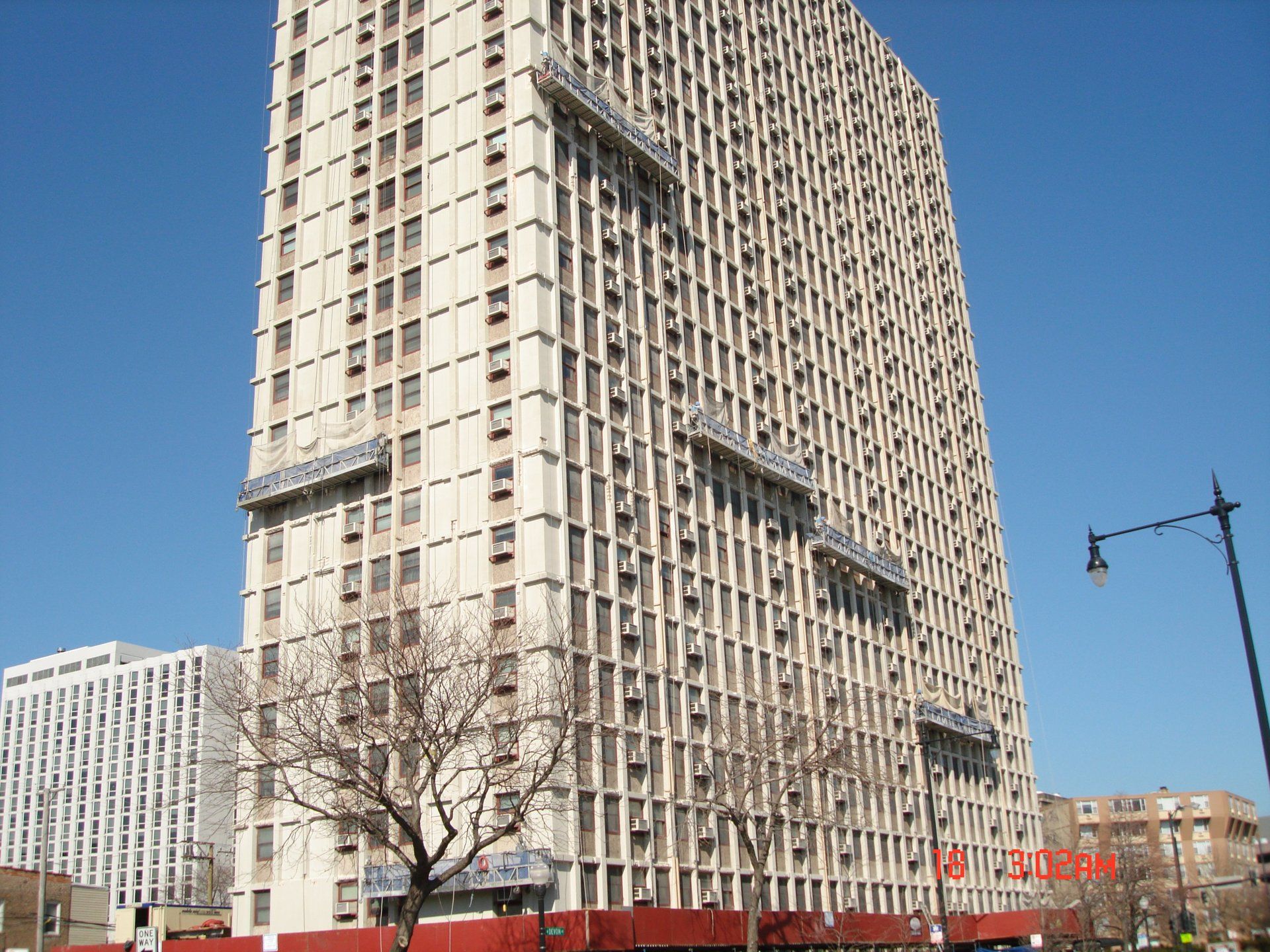 A tall building with a lot of windows and a street light in front of it