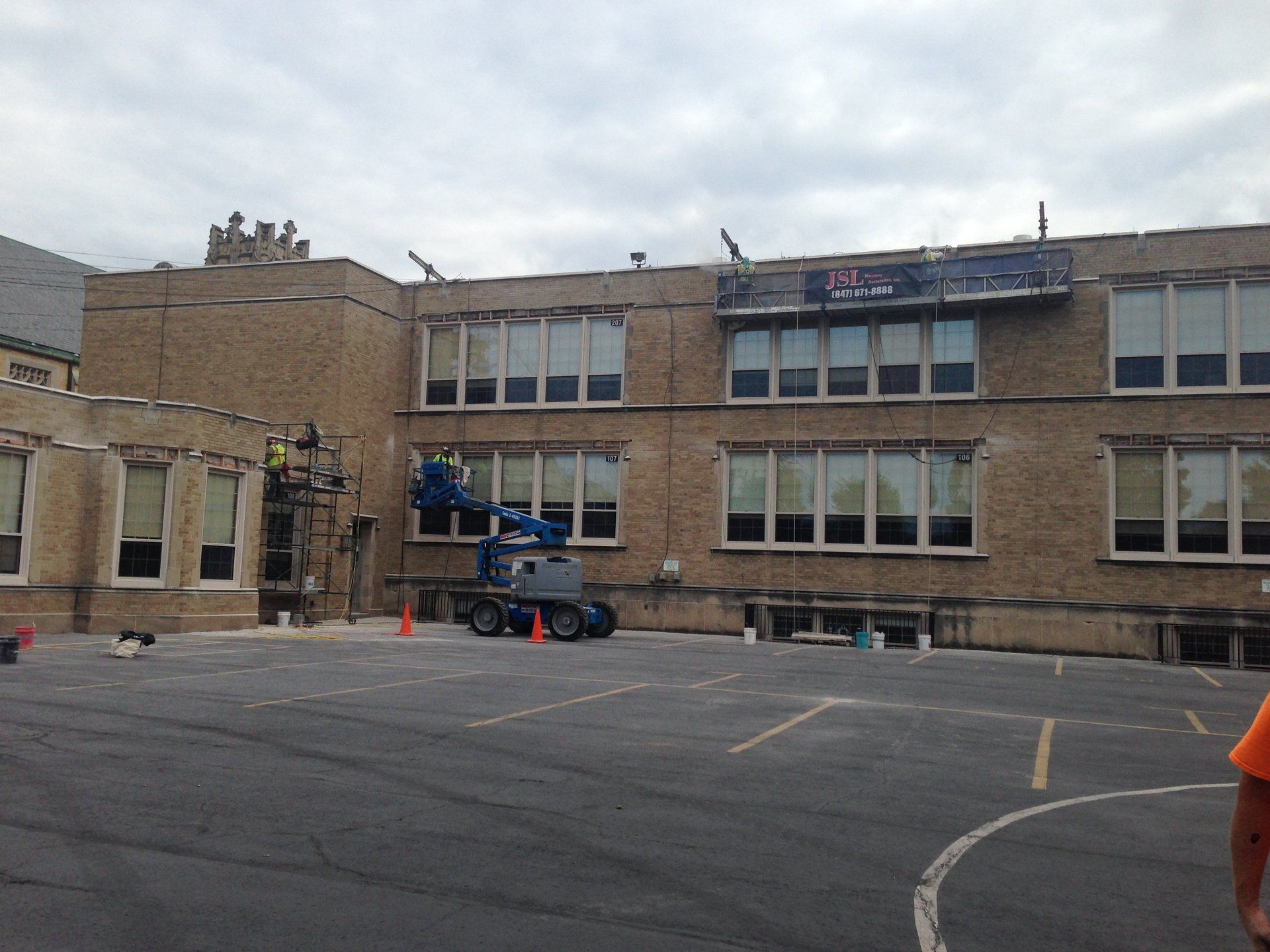 A large brick building with a basketball court in front of it