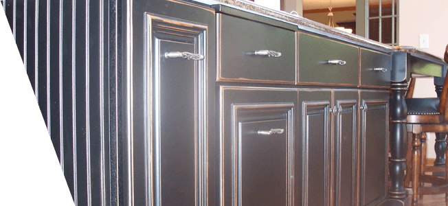 A kitchen with black cabinets and a granite counter top.
