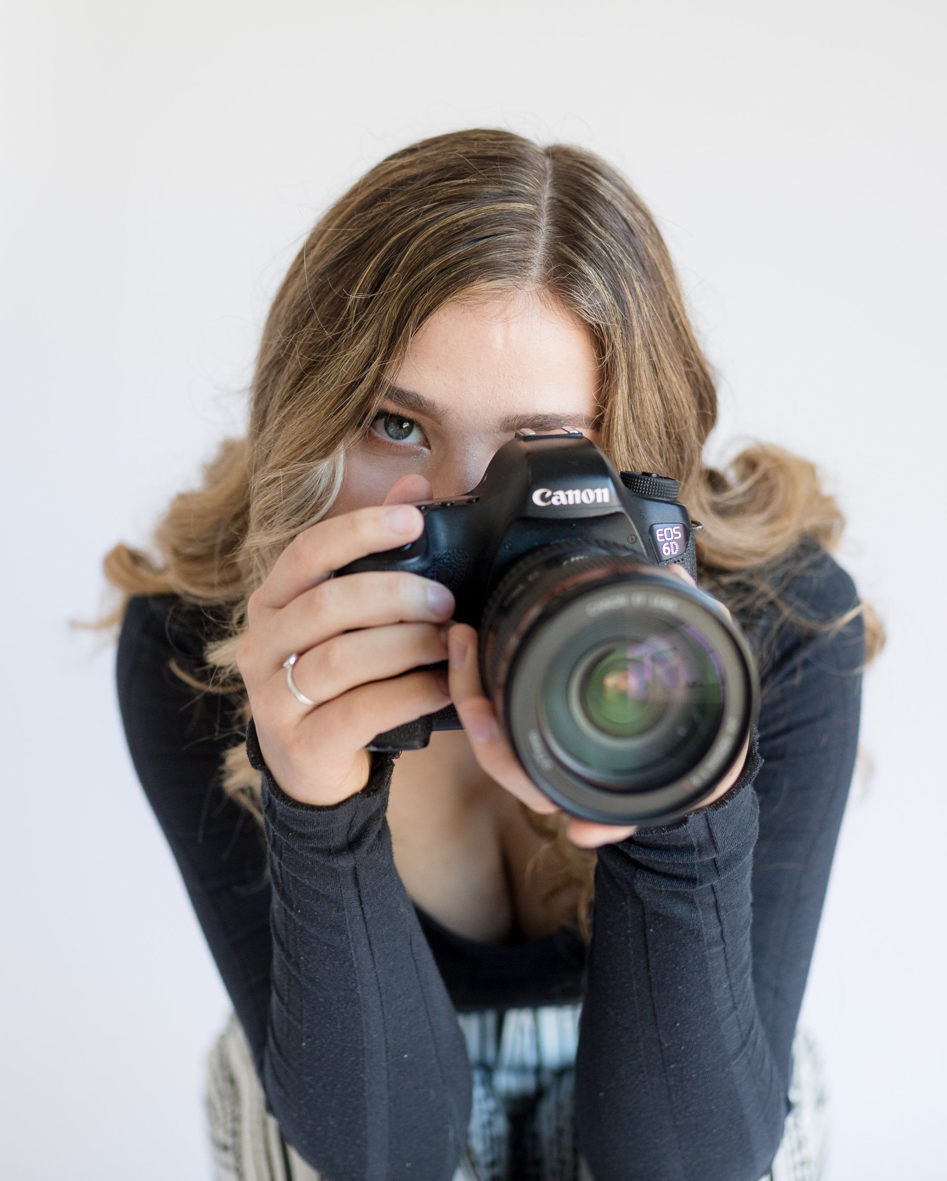 A woman is taking a picture with a canon camera