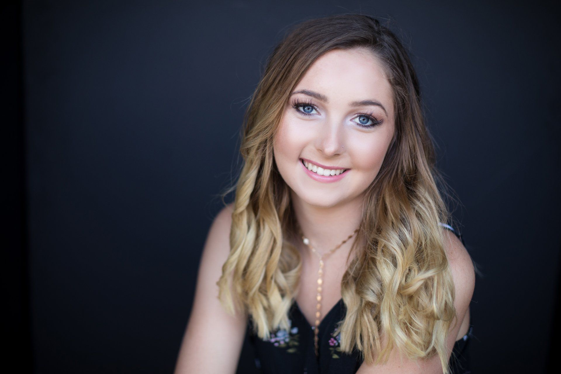 A young woman with long blonde hair is smiling for the camera.