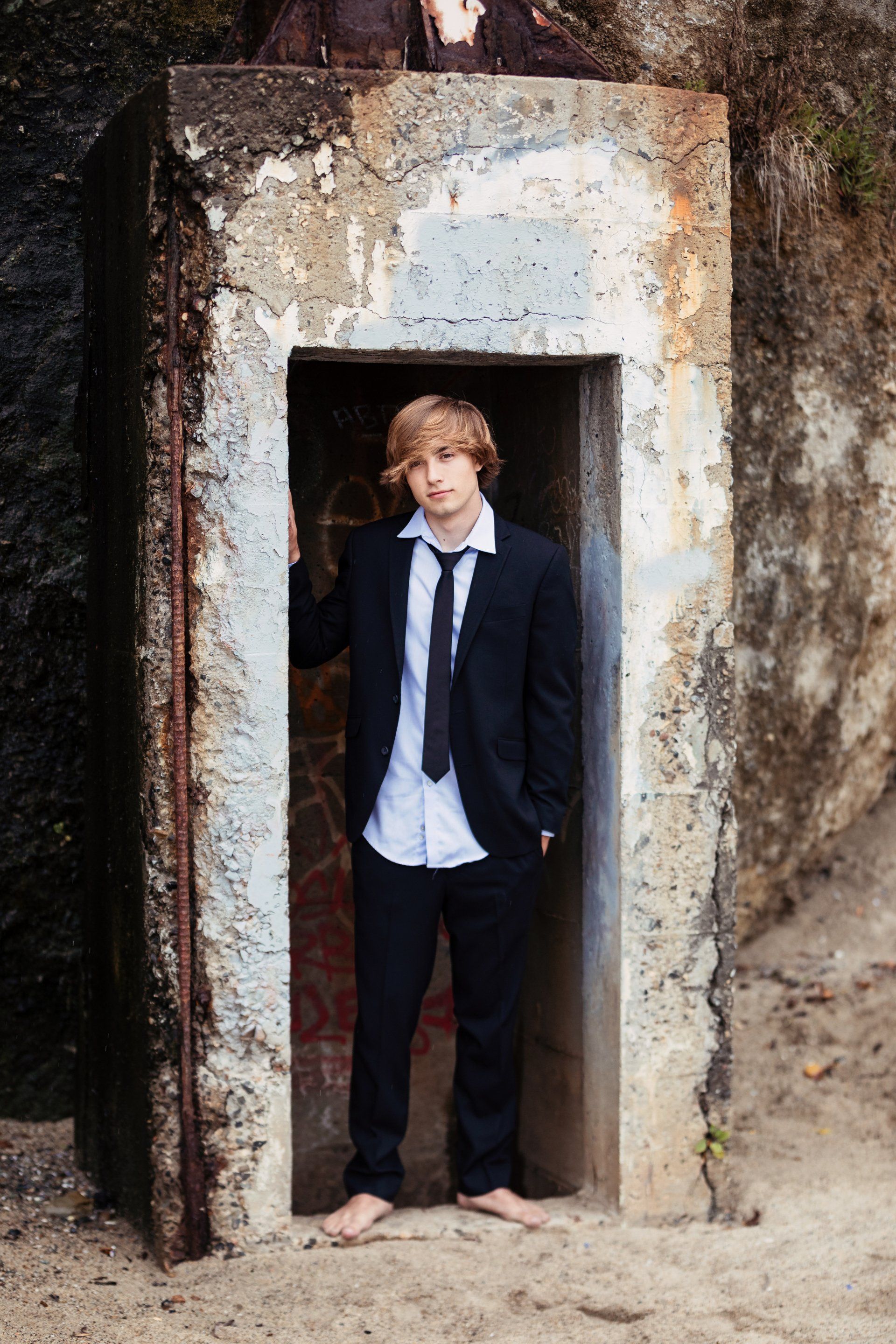 A man in a suit and tie is standing in a doorway.