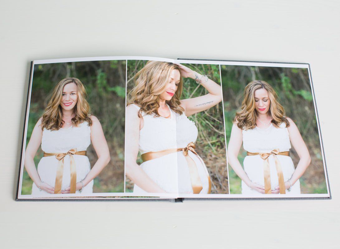 A pregnant woman in a white dress is holding her belly in a photo album.