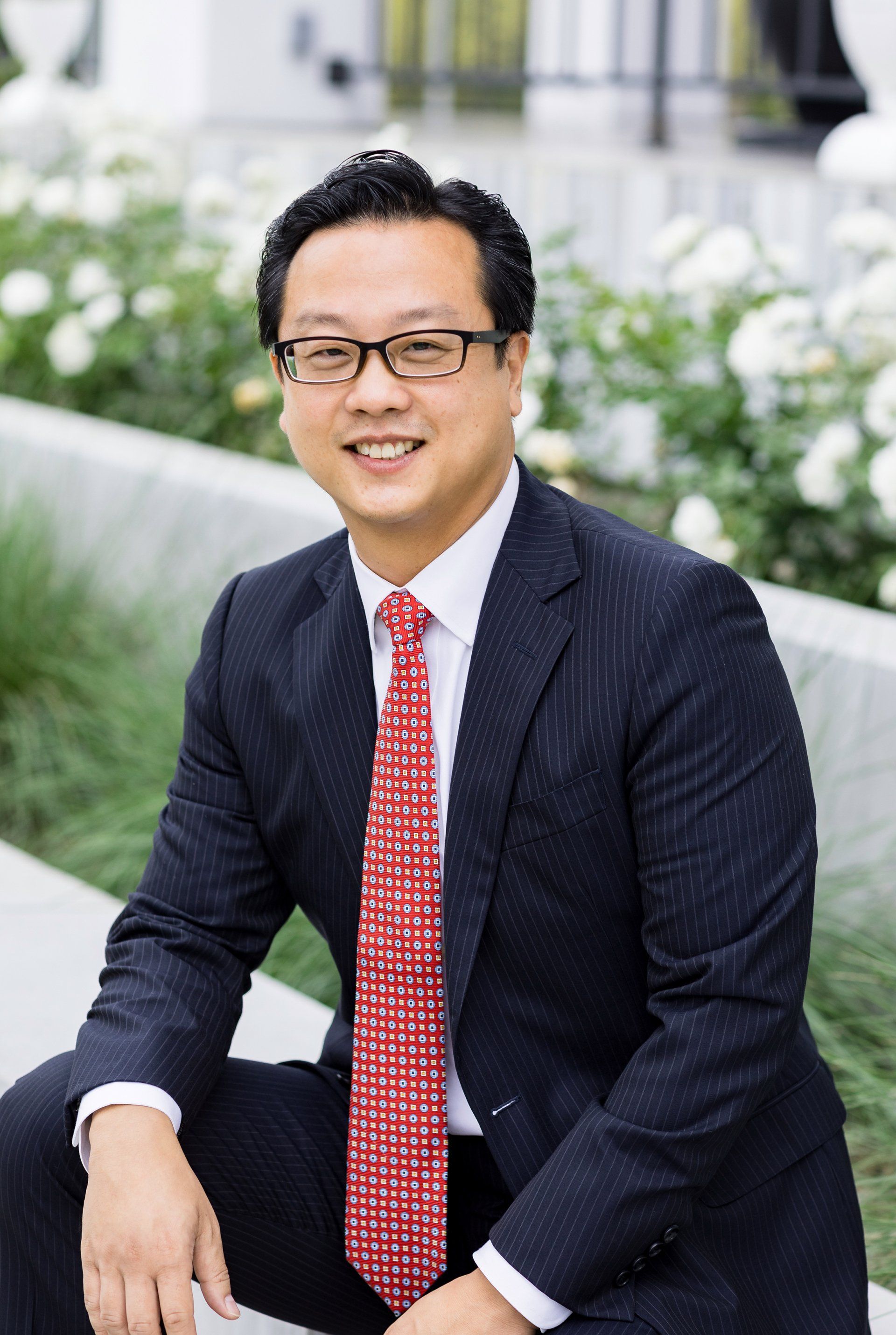 A man in a suit and tie is sitting on a bench.