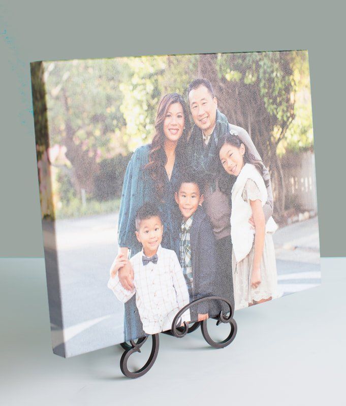 A canvas print of a family standing next to each other on a table.