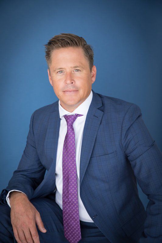Executive corporate headshot on a blue backdrop, Orange County