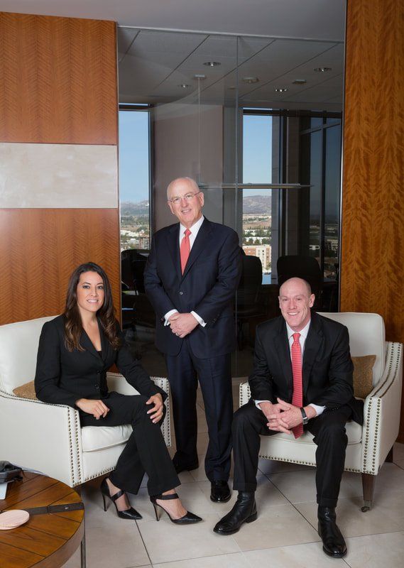Two men and a woman are posing for a picture in a living room.