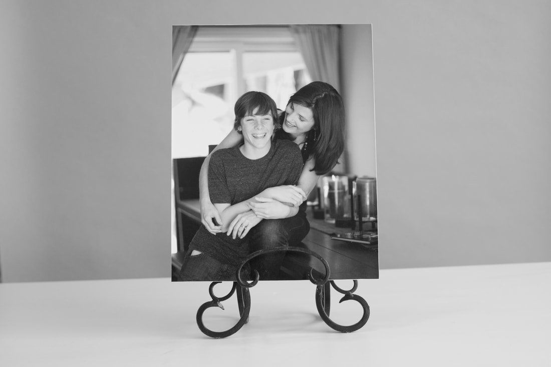 A black and white photo of a woman hugging a boy