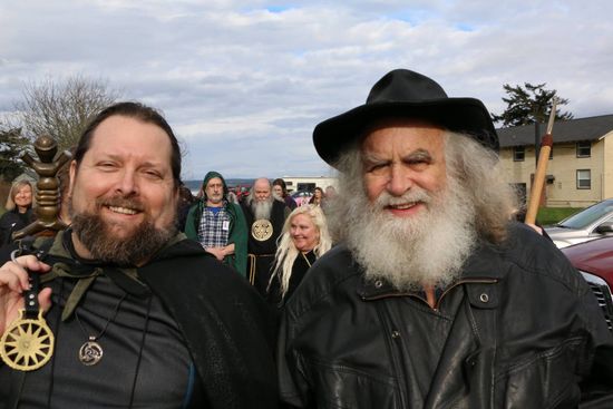 A man with a beard is standing next to another man with a beard.