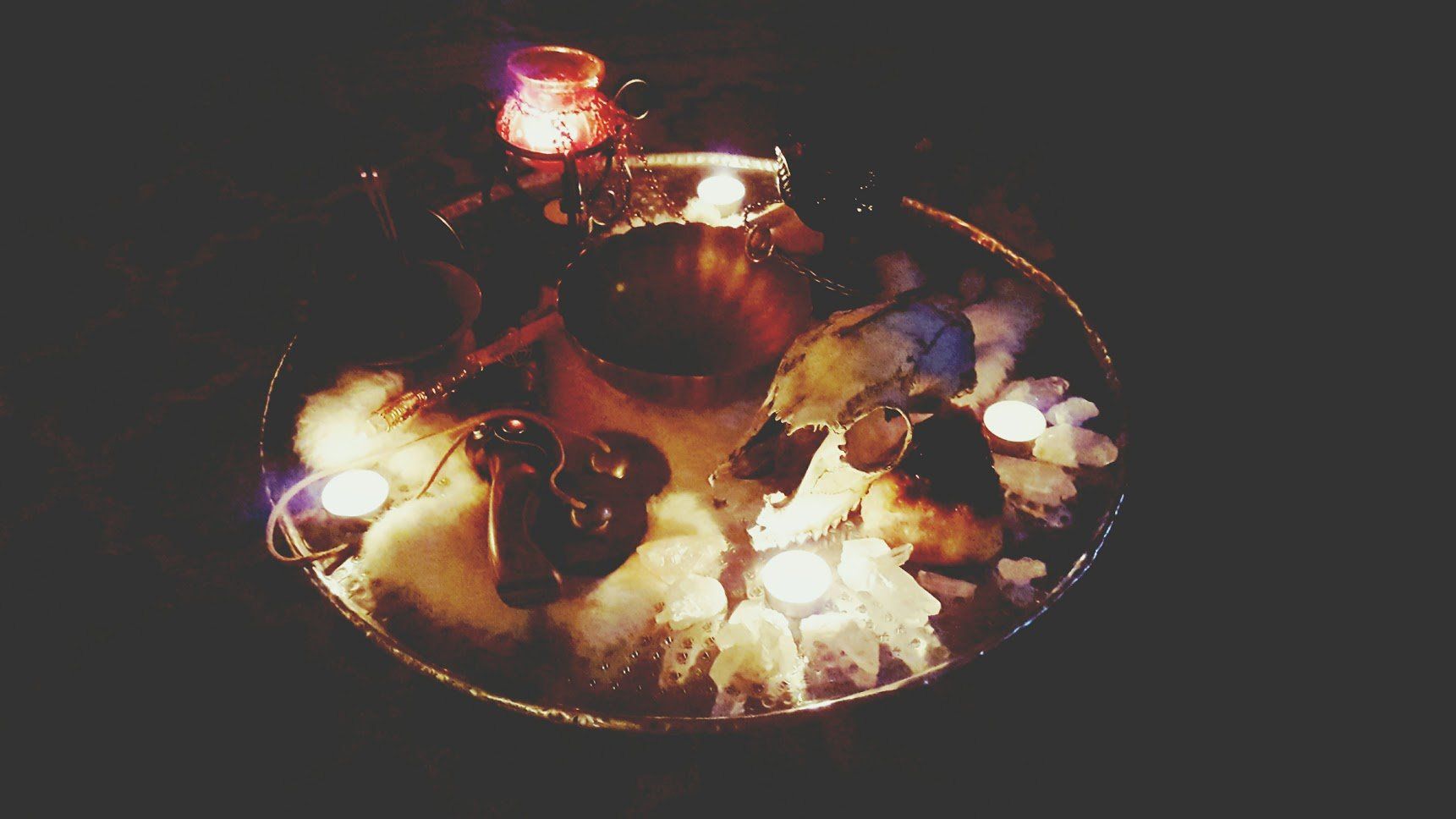 A bowl filled with candles and ice in a dark room.