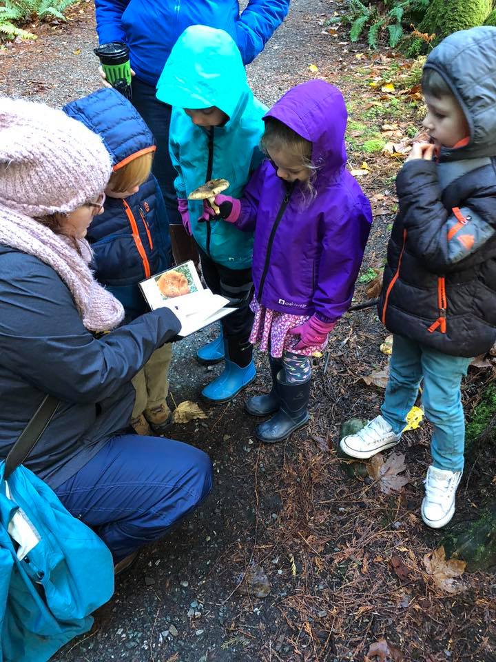 A woman is reading a book to a group of children.