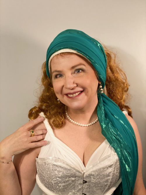 A woman wearing a white top and a green scarf around her head, Stacy Sylvester