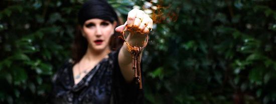 A woman in a black dress is holding a key in her hand.