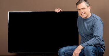Man sitting and holding TV set Man sitting and holding TV set