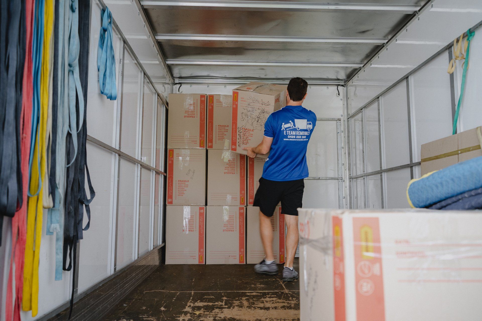 Mover loading stacked boxes inside a truck trailer