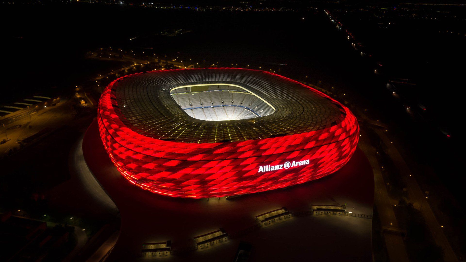 Eine Luftaufnahme eines nachts beleuchteten Fußballstadions.