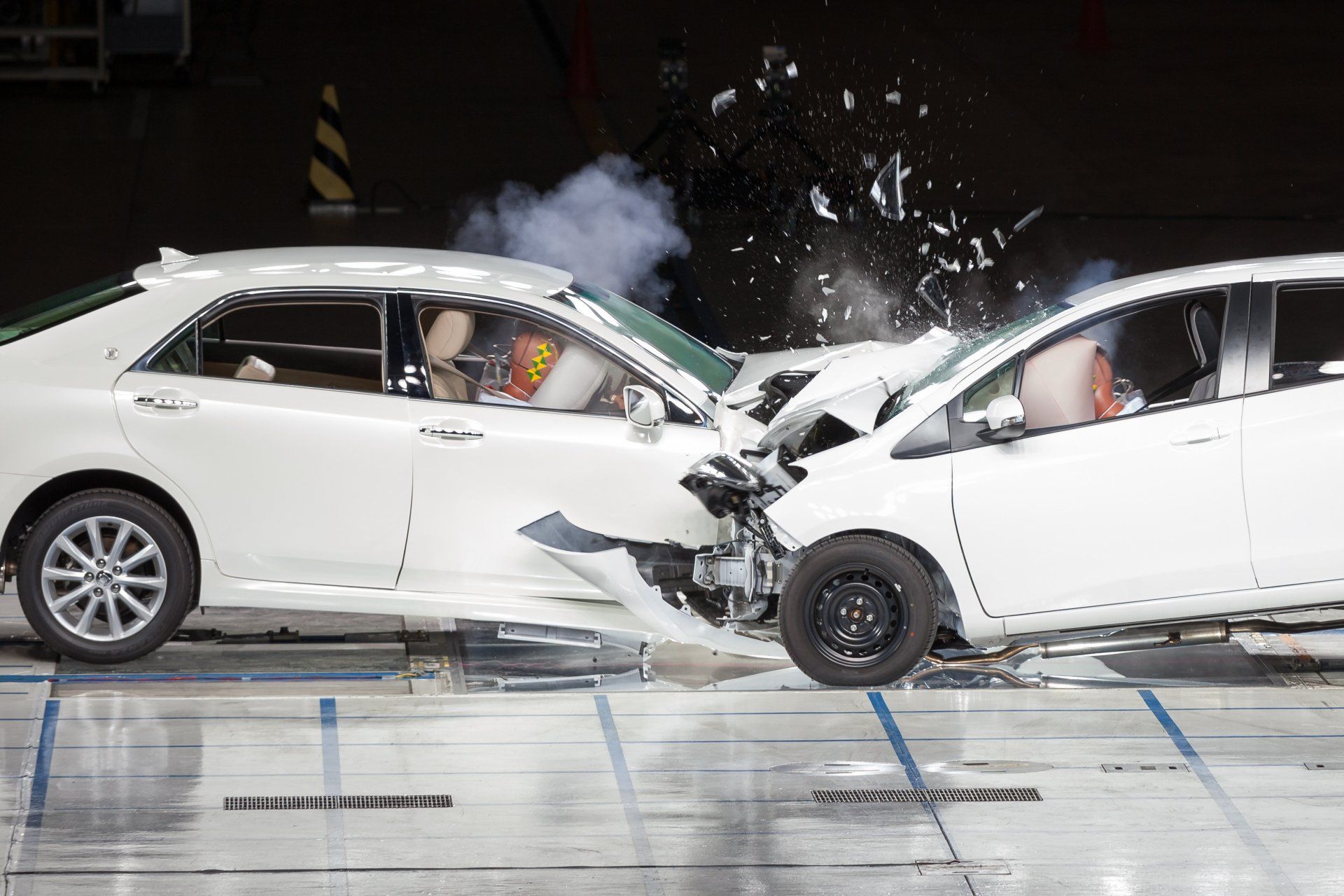 Two white cars are crashed into each other on a test track.