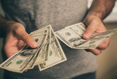 Bill Pay — A Man Holds Dollars In His Hands in Long Branch, NJ