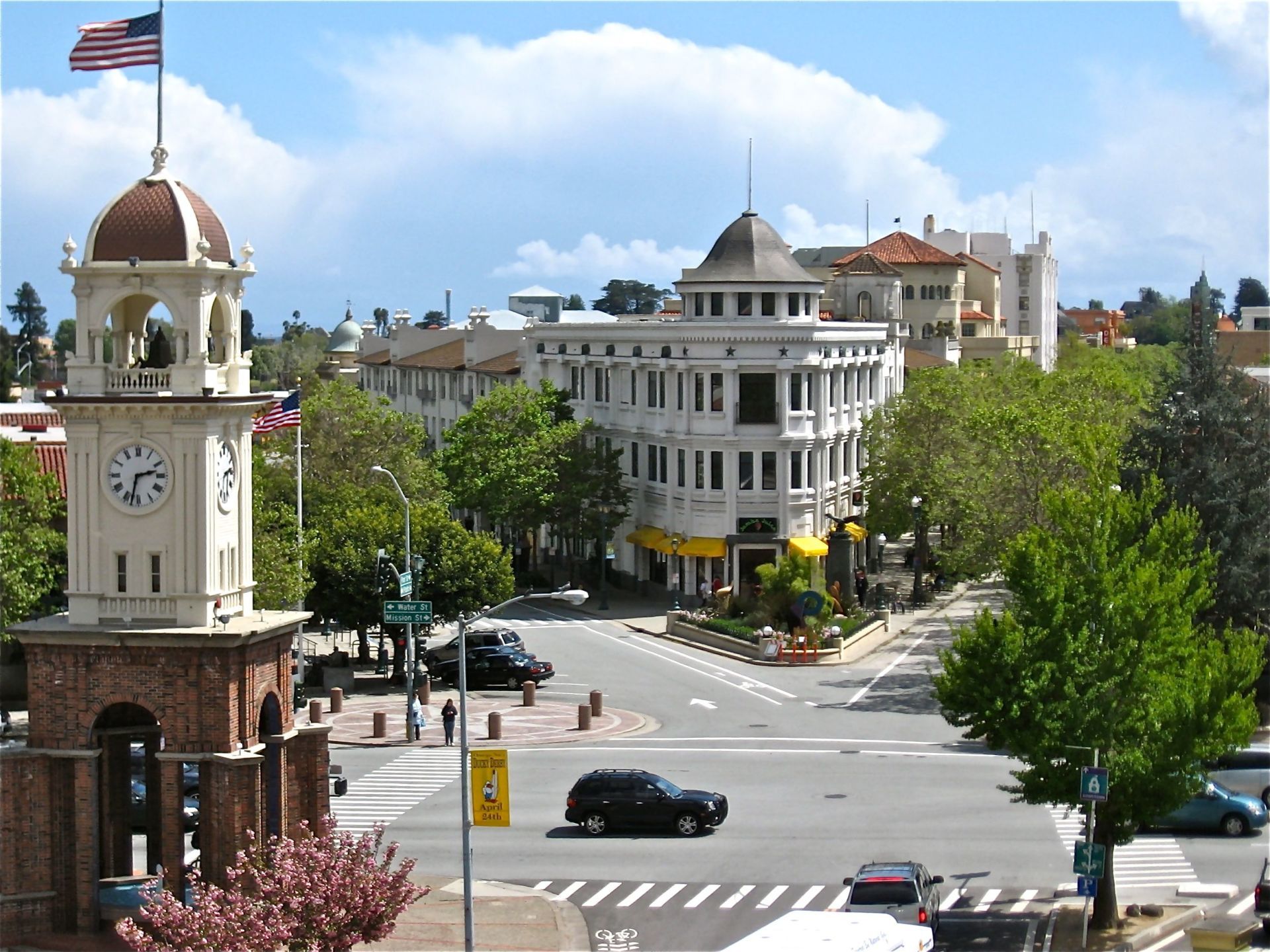 Historic downtown intersection with clock tower, domed building, and cars under a blue sky | Tony Wood Commercial Real Estate