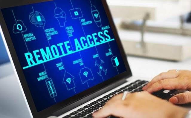 A person is typing on a laptop computer with the word remote access on the screen.