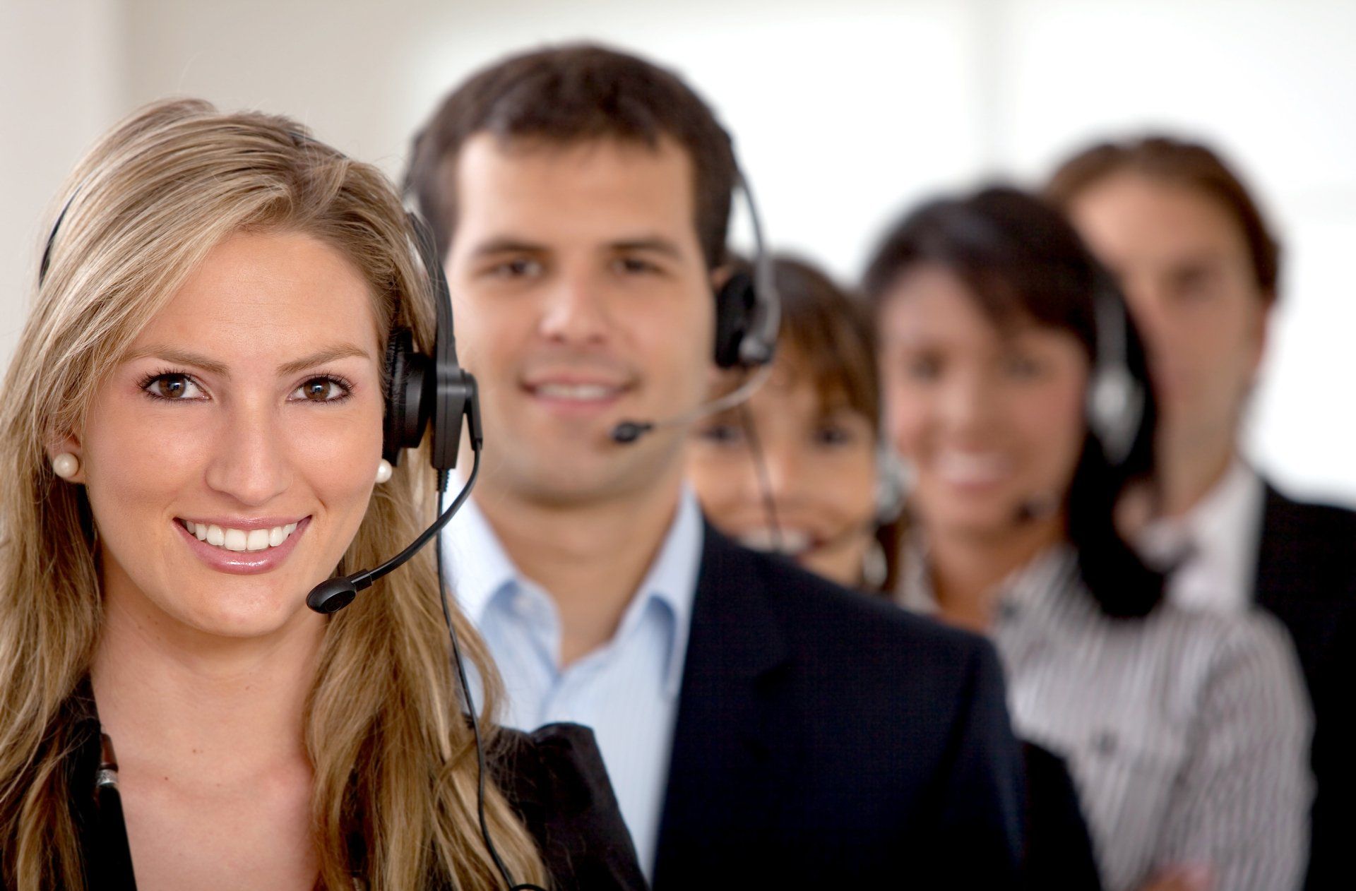 A group of people wearing headsets are smiling for the camera