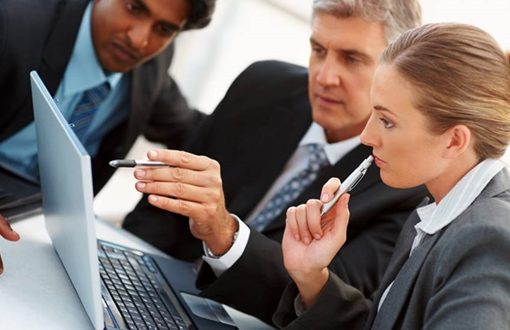 A group of business people are looking at a laptop computer