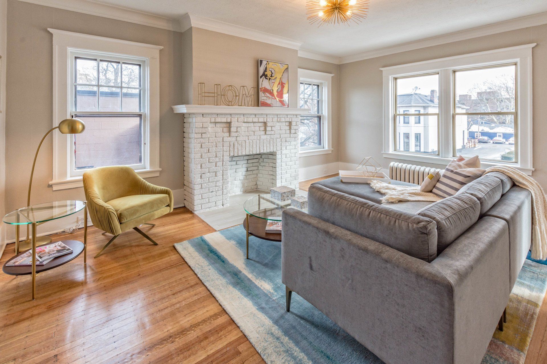 Living room with fireplace, hardwood floors, and bright natural lighting