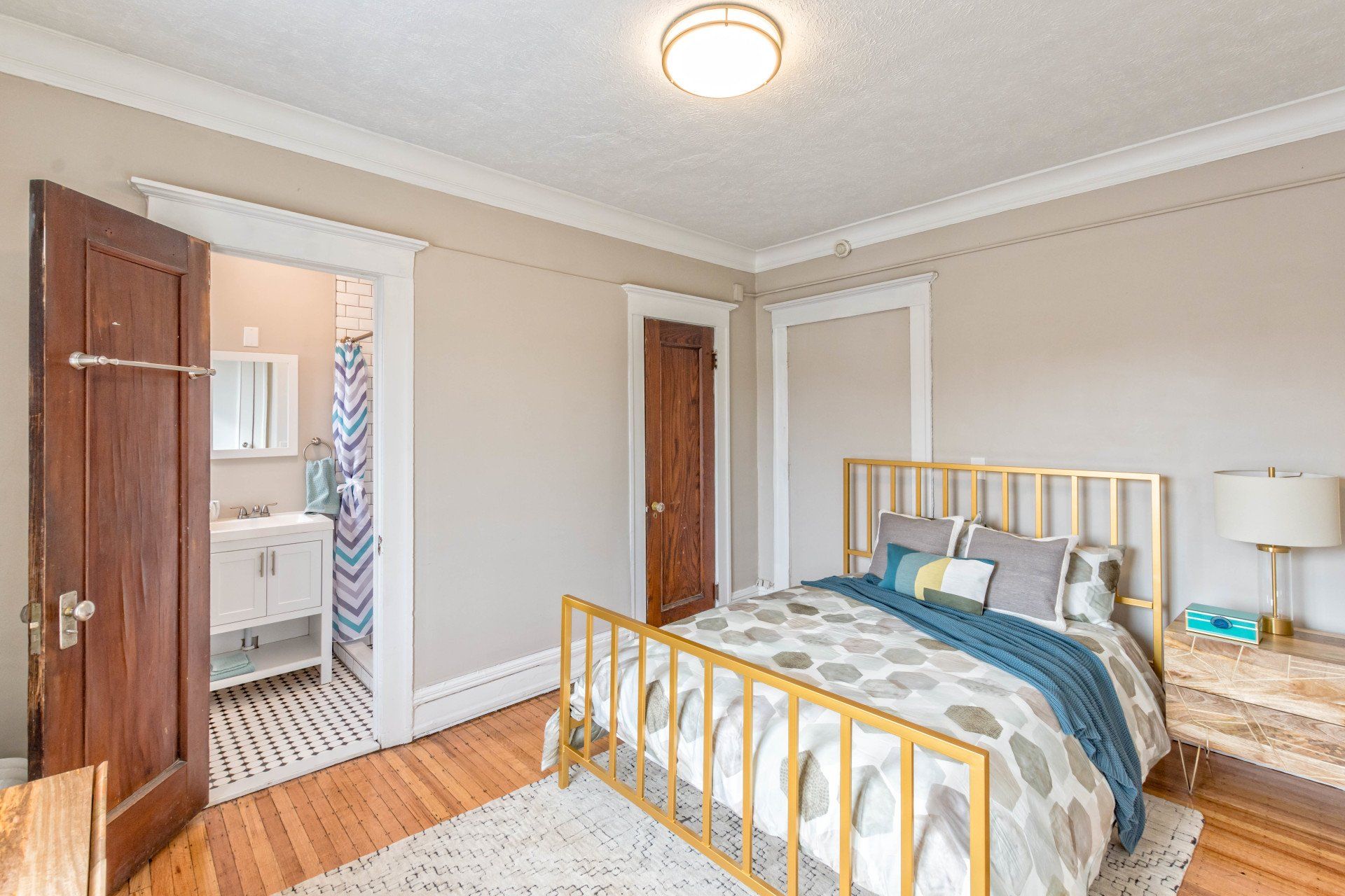Bedroom with hardwood floors, original wooden doors, and en suite bathroom