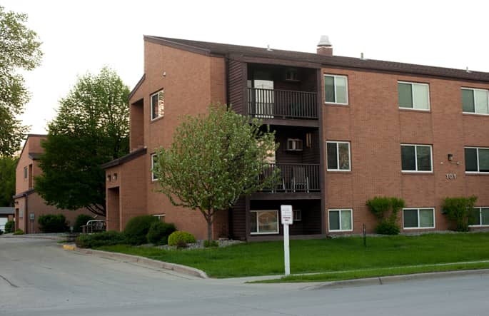 Three-story, brick apartment building with brown trim