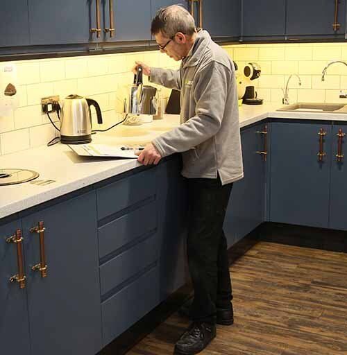 Cleaning supervisor checking tasks are finished in office kitchen