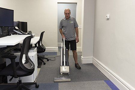 Vacuuming office carpet tiles before Dry Fusion cleaning