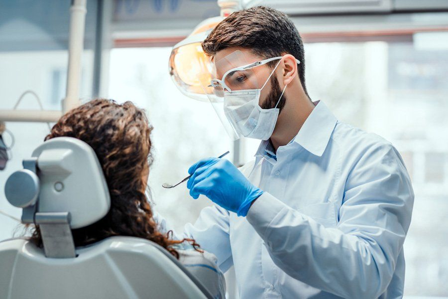 Dentist Checking Patients Teeth — Eastpointe, MI — Eastland & Professional Dental Center Dentist Checking Patients Teeth — Eastpointe, MI — Eastland & Professional Dental Center
