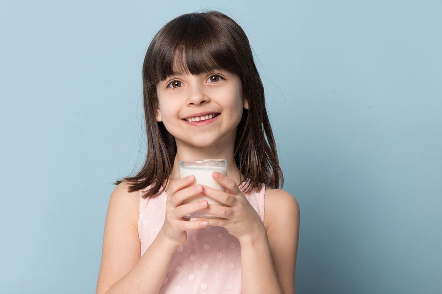 Girl Holding a Glass of Milk — Eastpointe, MI — Eastland & Professional Dental Center Girl Holding a Glass of Milk — Eastpointe, MI — Eastland & Professional Dental Center