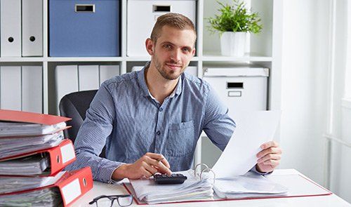 Young businessman calculates taxes Young businessman calculates taxes