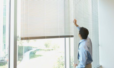 man adjusting the blinds