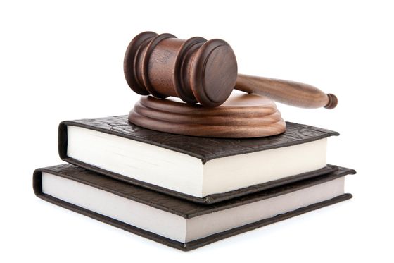 Judge’s gavel resting on two stacked law books isolated on white background