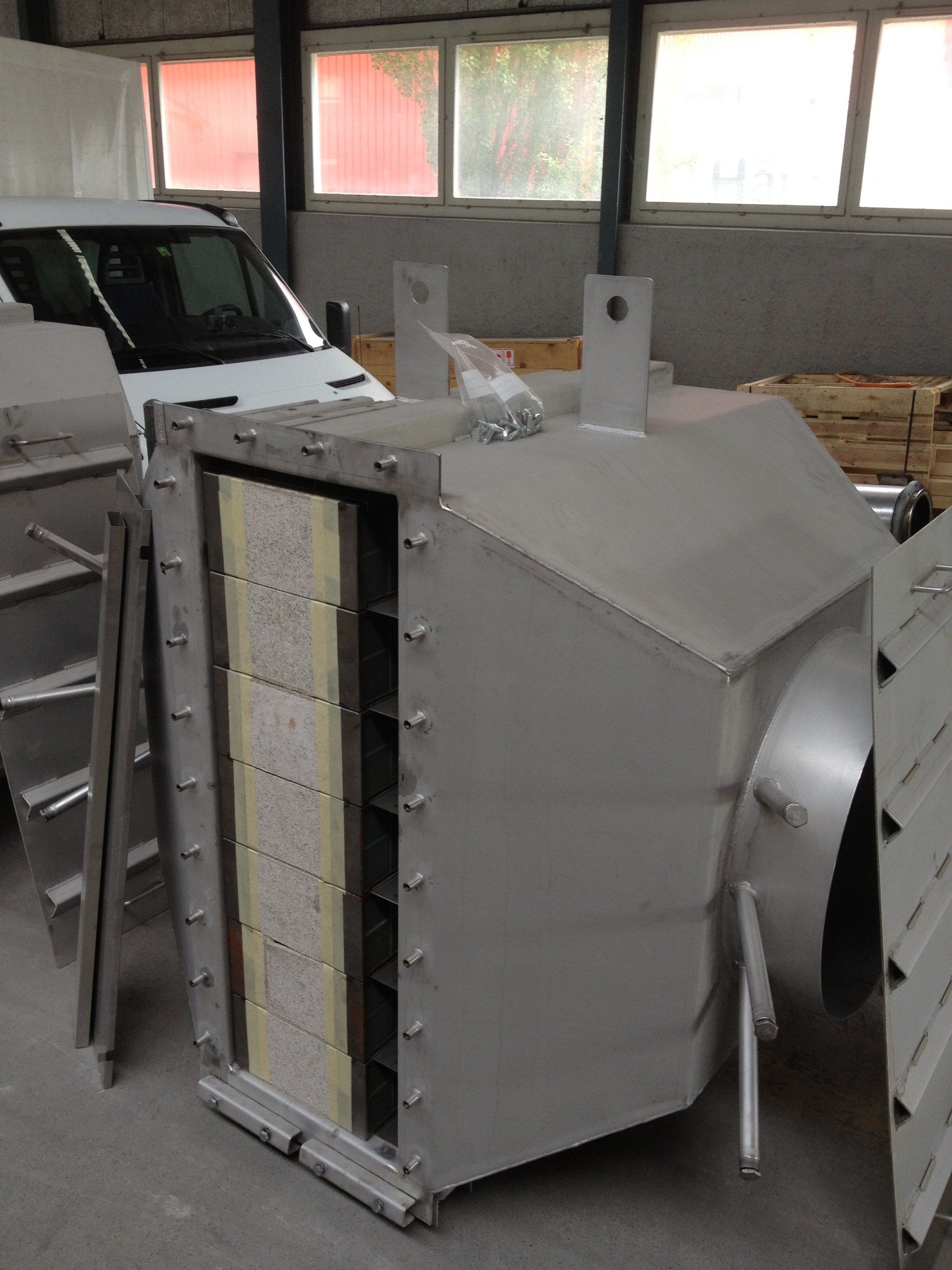 Une camionnette blanche est garée à côté d'une grande boîte grise