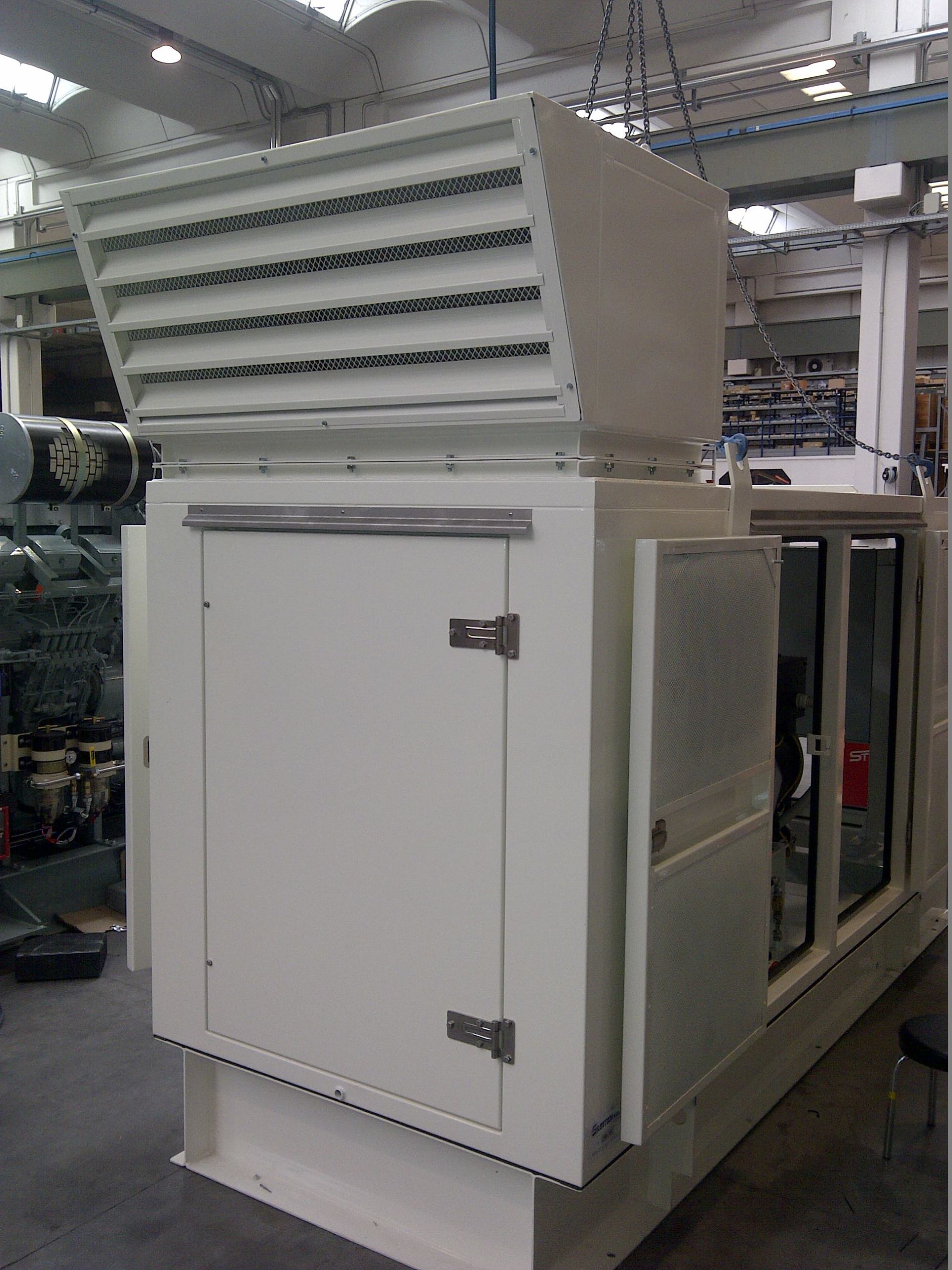 Une grande machine blanche est assise dans une usine avec la porte ouverte.