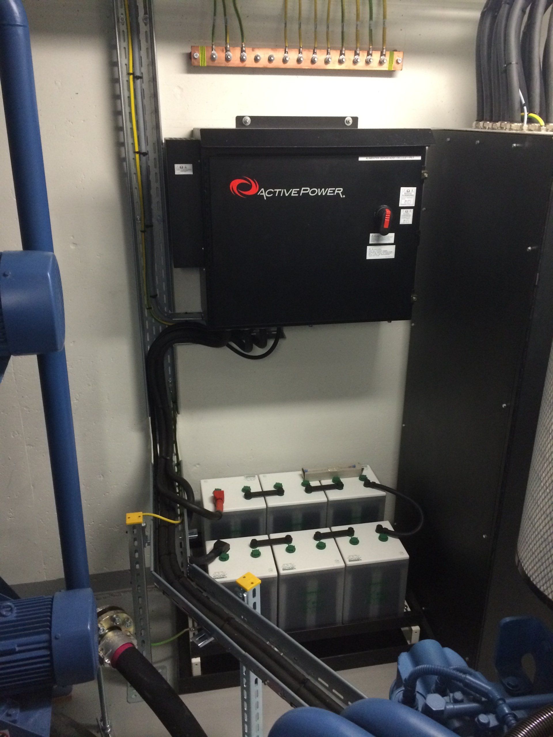 Une rangée de batteries est placée dans une pièce à côté d'une machine