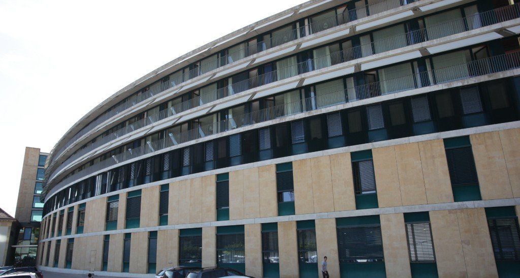 Ein großes Gebäude mit vielen Fenstern und einem geschwungenen Dach