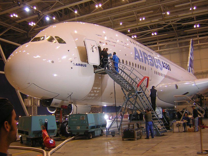 In einem Hangar wird an einem großen Airbus-Flugzeug gearbeitet