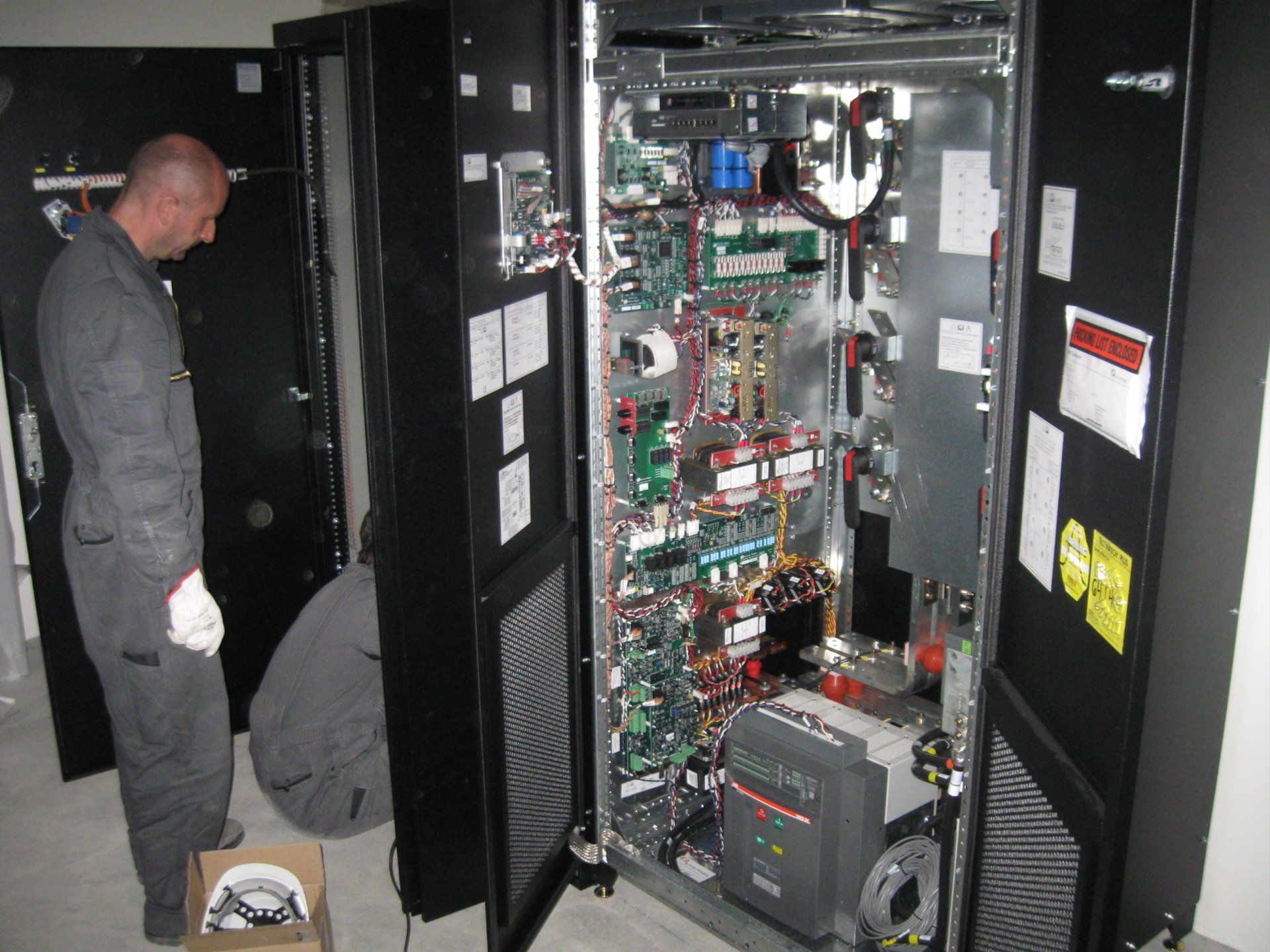 Zwei Männer arbeiten an einem großen Schaltschrank