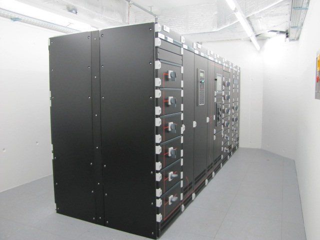 A room with a row of black cabinets with buttons on them