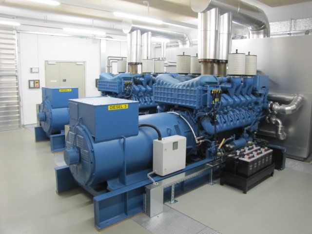 A row of blue generators are sitting in a room