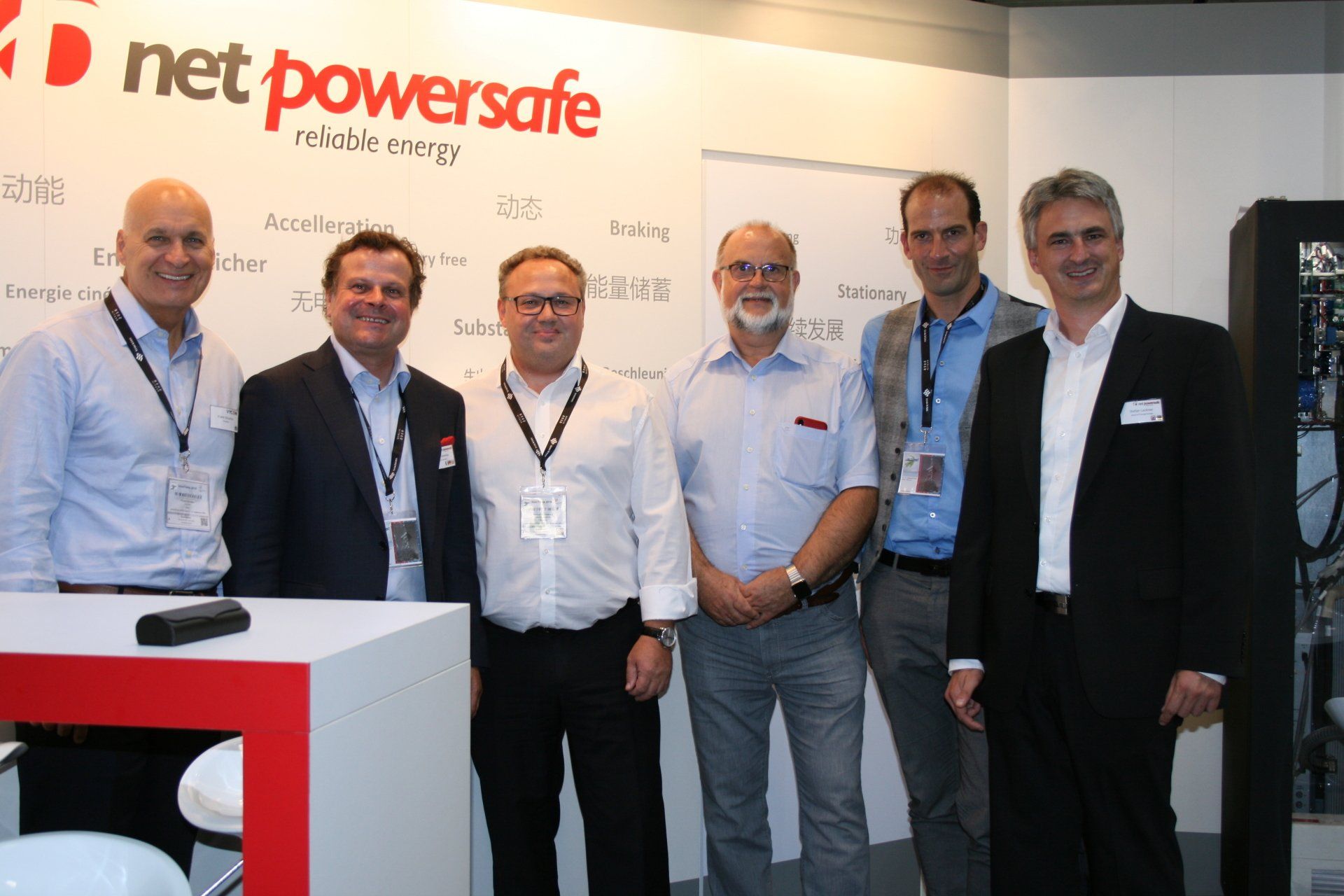 Un groupe d'hommes debout devant un mur sur lequel est écrit net powersafe