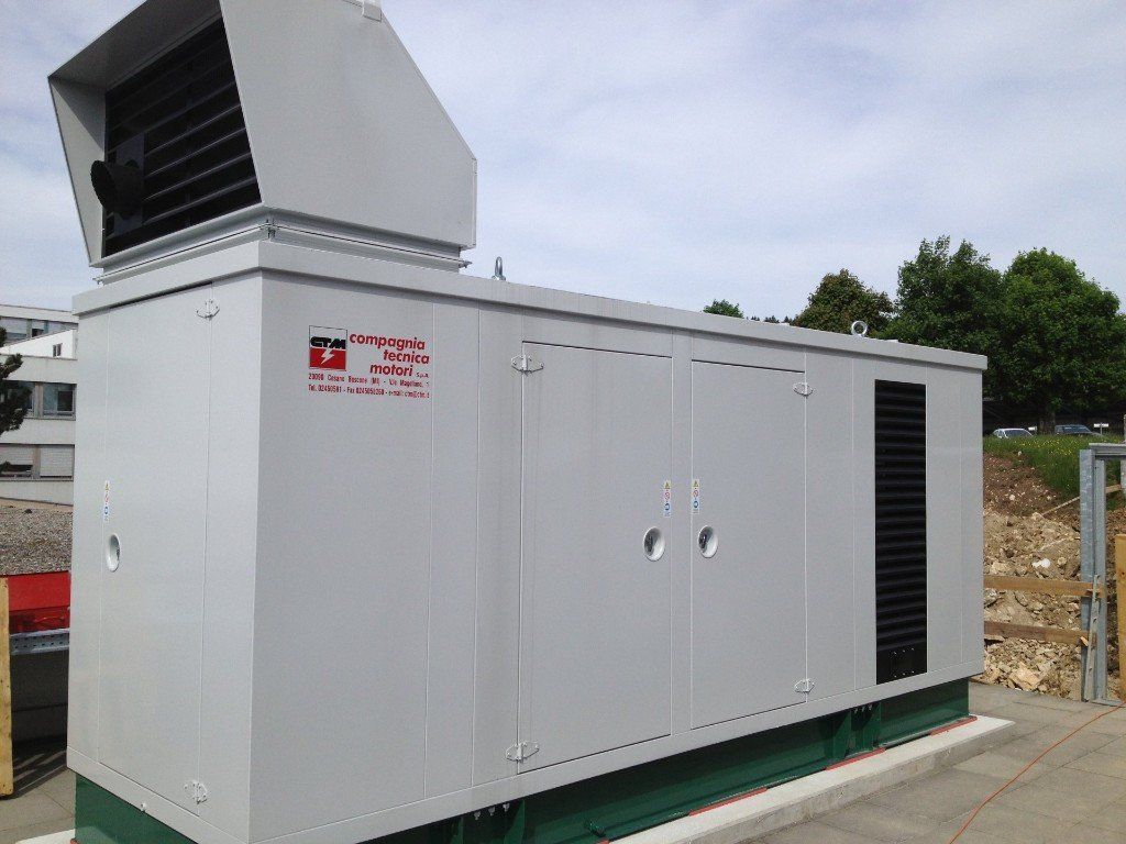 Un grand bâtiment blanc avec un grand ventilateur au sommet.