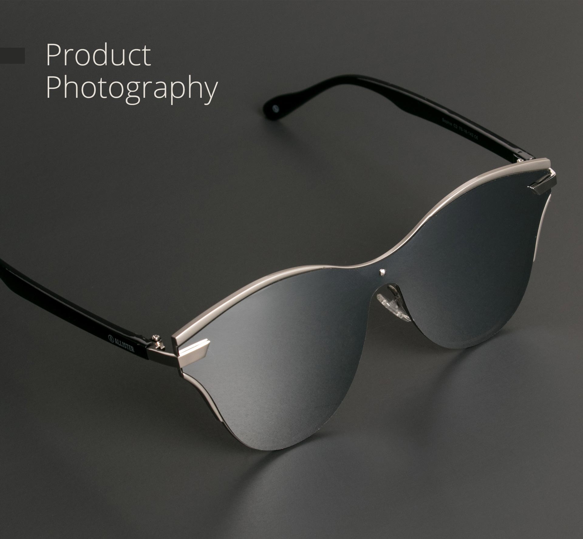Silver mirrored sunglasses on a dark surface.