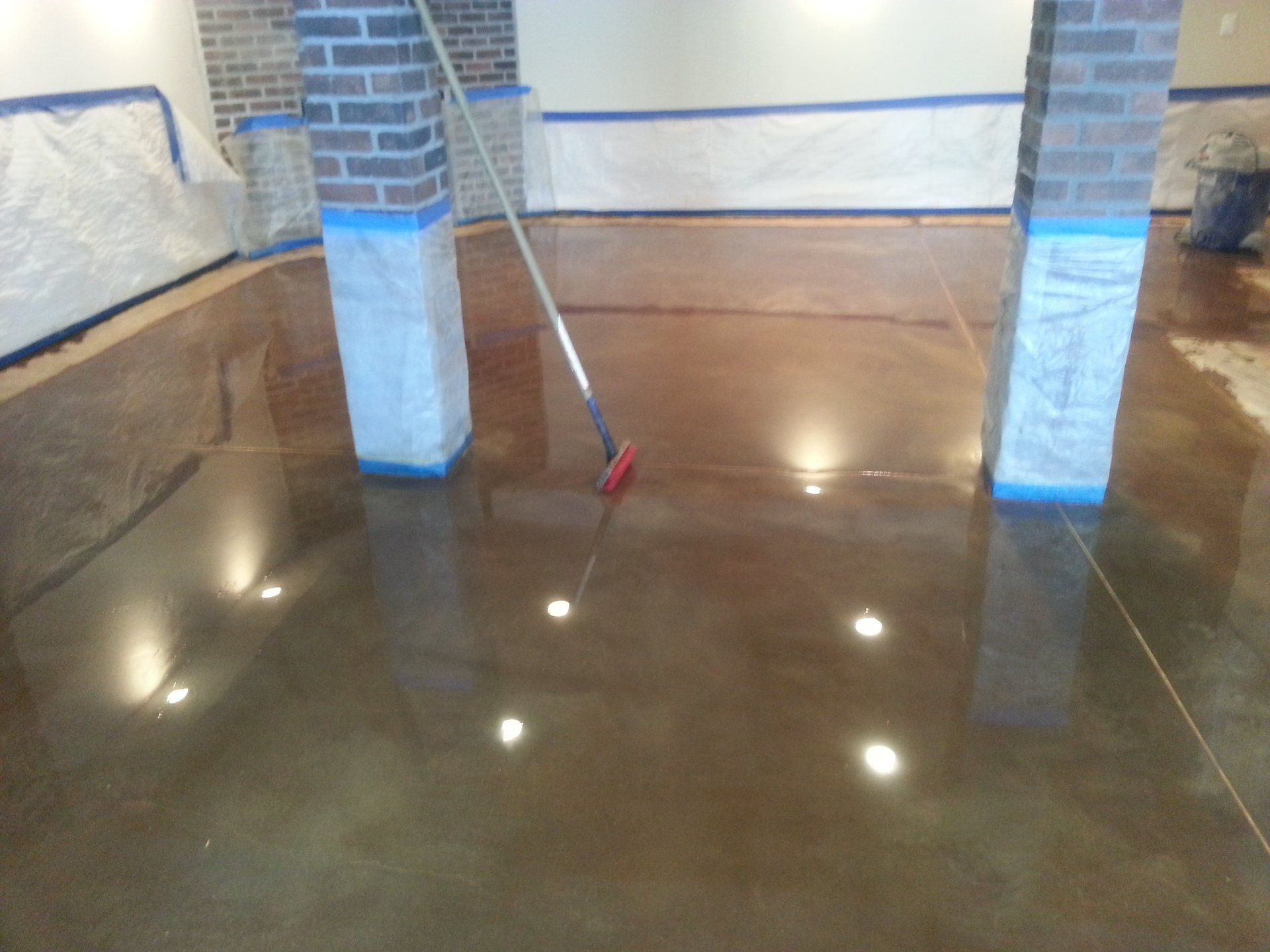 A broom is being used to clean a concrete floor